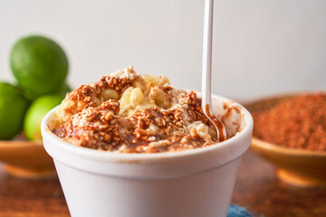 Esquite, mexican corn salad with chili and cheese, street food from mexico.