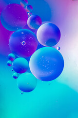 Abstract background in blue violet tones. Distortion in water with oil drops.