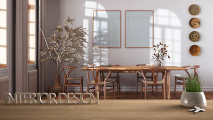Wooden table, desk or shelf with potted grass plant, house keys and 3D letters making the words interior design, over dining room with frame mockup, project concept copy space