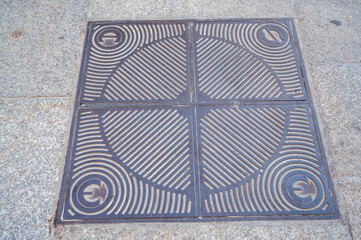 Dark metal hatch on sidewalk