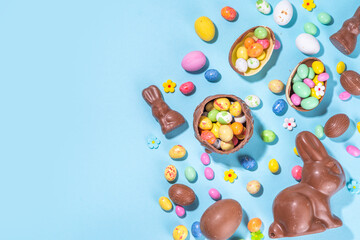 Easter chocolate egg and bunny background. High-colored flat lay with chocolate bunny and rabbits, colorful chocolate eggs. Preparation for Easter, greeting card, Easter sale, top view copy space