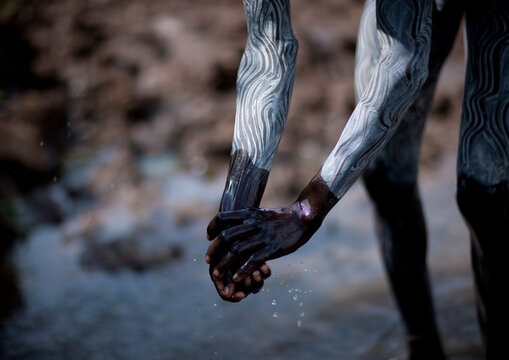 Clay body paintings on Suri warriors before donga stick fighting, Turgit village, Omo valley, Ethiopia