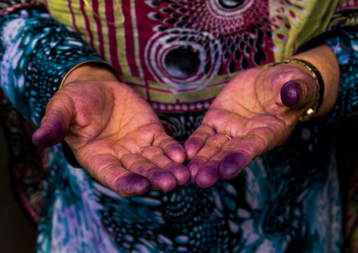 a bandari woman showing her hands with indigo traces after sewing a traditional burqa mask, Qeshm Island, Salakh, Iran