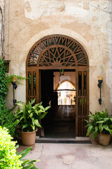 Fototapeta na wymiar courtyard garden with arched entrance with wood decoration. Historical building in Valldemossa, Mallorca spain. Exterior vintage architecture. Mediterranean style. 