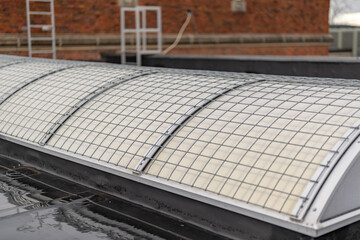 Barrel vault skylight screen fall protection guard installed on a commercial, industrial, or school skylight.  