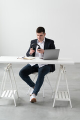 Focused young european man wear headphones, studying online, watching webinar podcast on laptop, listening to study, education course, conference calling, taking notes, sitting at desk