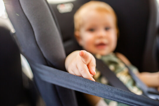 Child In Baby Rear Facing Car Seat Pointing To Camera