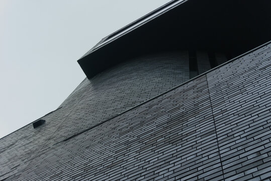 Fototapeta nowoczesny budynek z ciemnej cegły na tle jasnego nieba