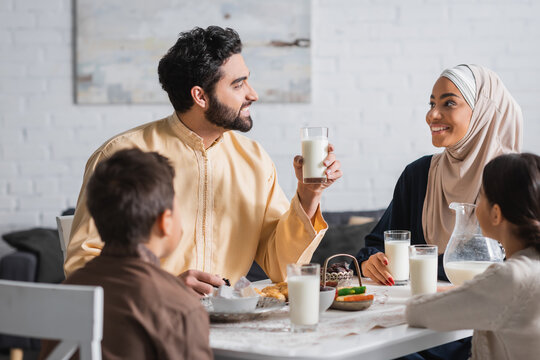 Smiling middle eastern family talking during ramadan breakfast at home.