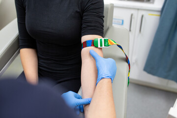Close up shot of a woman with a tourniquet on her arms for a blood test in the clinic