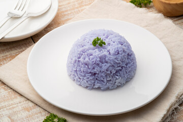 Cooked rice with anchan flower,purple rice from Butterfly pea (Clitoria ternatea L) in white plate
