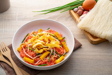 Stir fry rice vermicelli with Yen Ta Fo sauce.Pink sweet and sour thin rice noodles in white plate.Most popular and well known noodle dishes in Thailand