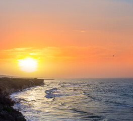 Fototapeta premium sea cape silhouette above quiet sea bay at the red dramatic sunset