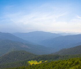 Obraz premium mountain valley in blue mist at the early morning, summer moutain travel background
