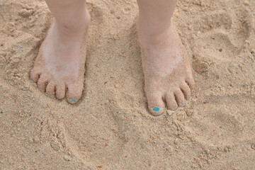 Fototapeta na wymiar Feet are on the sand right on the beach, sea summer vacation.