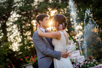 Fototapeta premium Husband and wife embracing on their wedding day at sunset