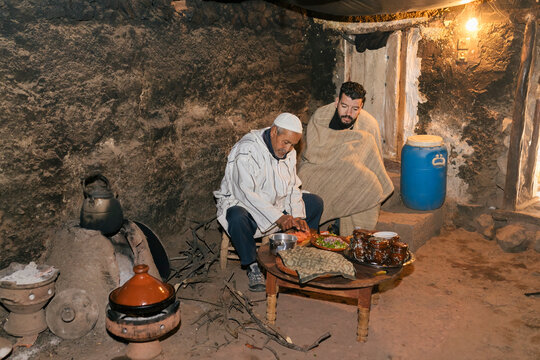 A father and son berber preparing food together to cook in a timeless traditional kitchen