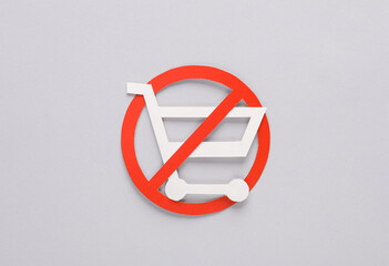 Paper cut shopping cart with prohibition sign on gray background