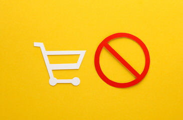 Paper cut shopping cart with prohibition sign on yellow background