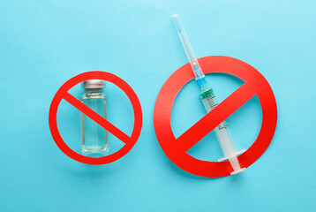 Vaccine bottle with syringe and prohibition sign on blue background