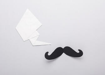 Paper men's mustache with a speech bubble on a gray background