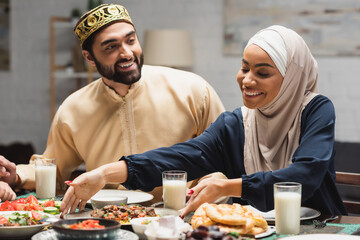 Smiling muslim family having ramadan dinner at home.
