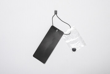 Black blank clothing price tag or label mockup with string on gray background. Sale, shopping concept