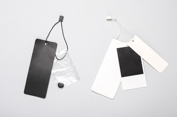 Blank clothing price tags or labels mockup with strings on gray background. Sale, shopping concept