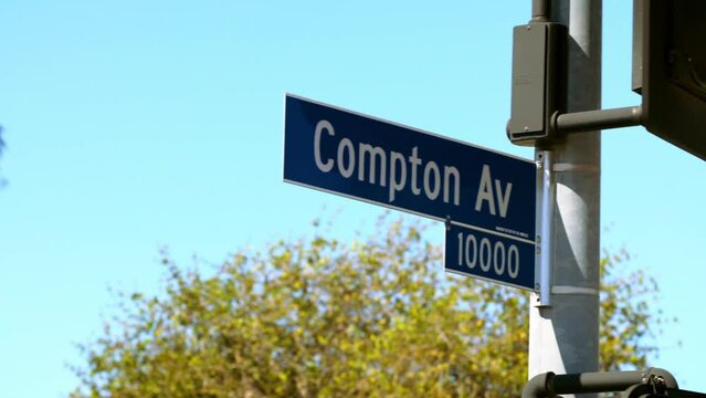 Panning Past Trees To A Blue Compton Street Sign  - Los Angeles, California