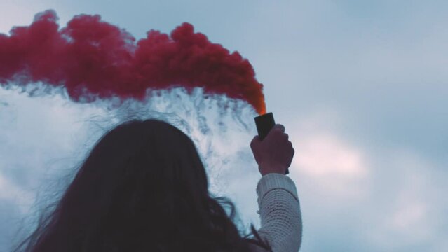 Red smoke, hand flare and happy woman having fun and spinning around during travel vacation or holiday outside. Freedom, travel and celebration with a happy female holding color bomb or grenade