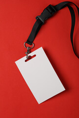 Empty white ID card badge mockup with black belt on red background. Staff identity name tag. Space...