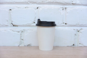 White cardboard coffee cup mockup on white brick wall background