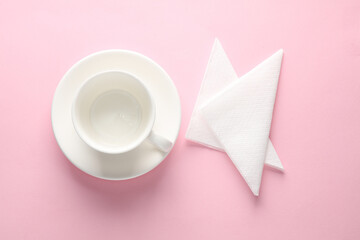 Empty Ceramic cup with napkin on pink background. Top view