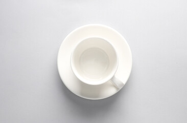 Obraz na płótnie Canvas Empty ceramic cup with saucer on gray background. Top view
