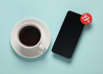 Cup of tea, smartphone and Notification with 99 number on blue background. Social media chat, message, sms, subscribe notice alert and reminder. Top view