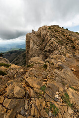 imagen de la cima de una montaña de piedra con el cielo lleno de nubes 