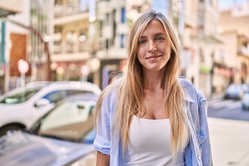 Fototapeta premium Young blonde woman smiling confident standing at street