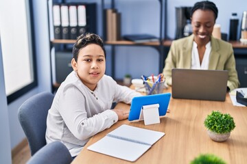 African american mother and son using laptop and touchpad working at office