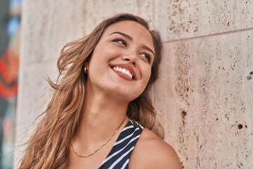 Young beautiful hispanic woman smiling confident looking to the side at street