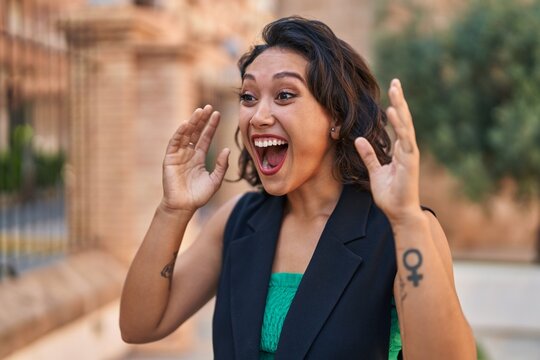 Young beautiful hispanic woman standing with surprise expression at street