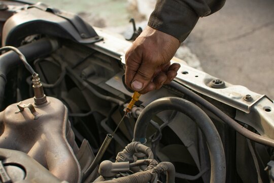 mechanic cheks the oil in the car
