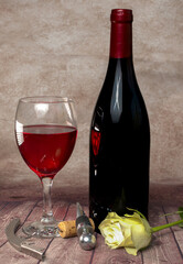 A bottle of red wine A bottle of wine and a glass on the background Wine and wine opener Romantic...