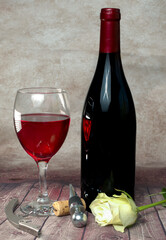 A bottle of red wine A bottle of wine and a glass on the background Wine and wine opener Romantic...