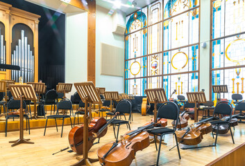 stringed musical instruments of the symphony orchestra lie on the stage before the concert...