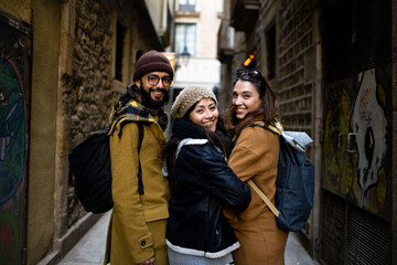 Happy group of friends looking back at camera - cheerful tourists on holidays - Friendship, happiness and travel concept