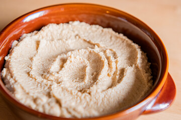 Home made hummus in a bowl on a wooden table