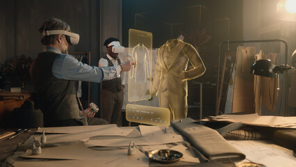 Tailor and male African American customer in VR headsets in atelier. 3D hologram of suit pattern. Virtual interface menu of software for designing and modeling garment. Modern digital AR devices.
