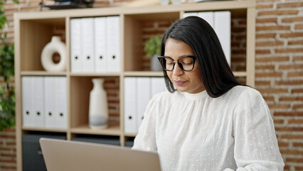 Fototapeta na wymiar Young beautiful latin woman business worker using laptop working at office