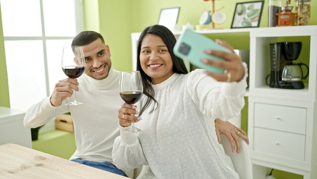 Man and woman couple make selfie by smartphone holding glass of wine at home
