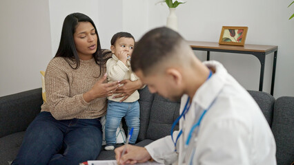 Obraz premium Couple and son having medical consultation at clinic